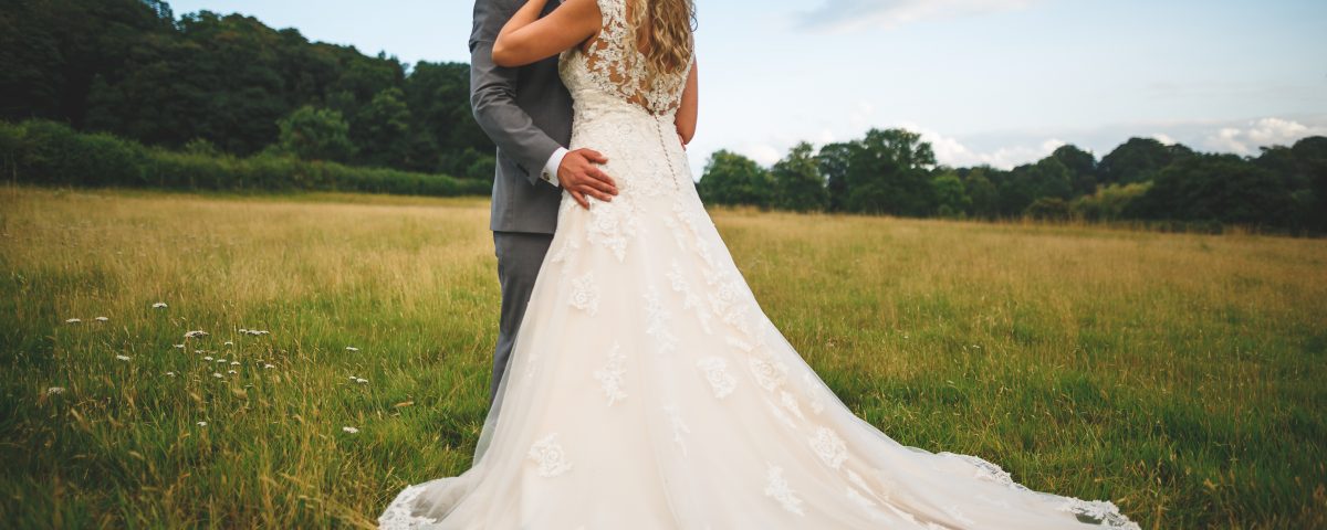 Wedding at Slaters Country Inn, Wedding dress shot with newlywed couple kissing in a field