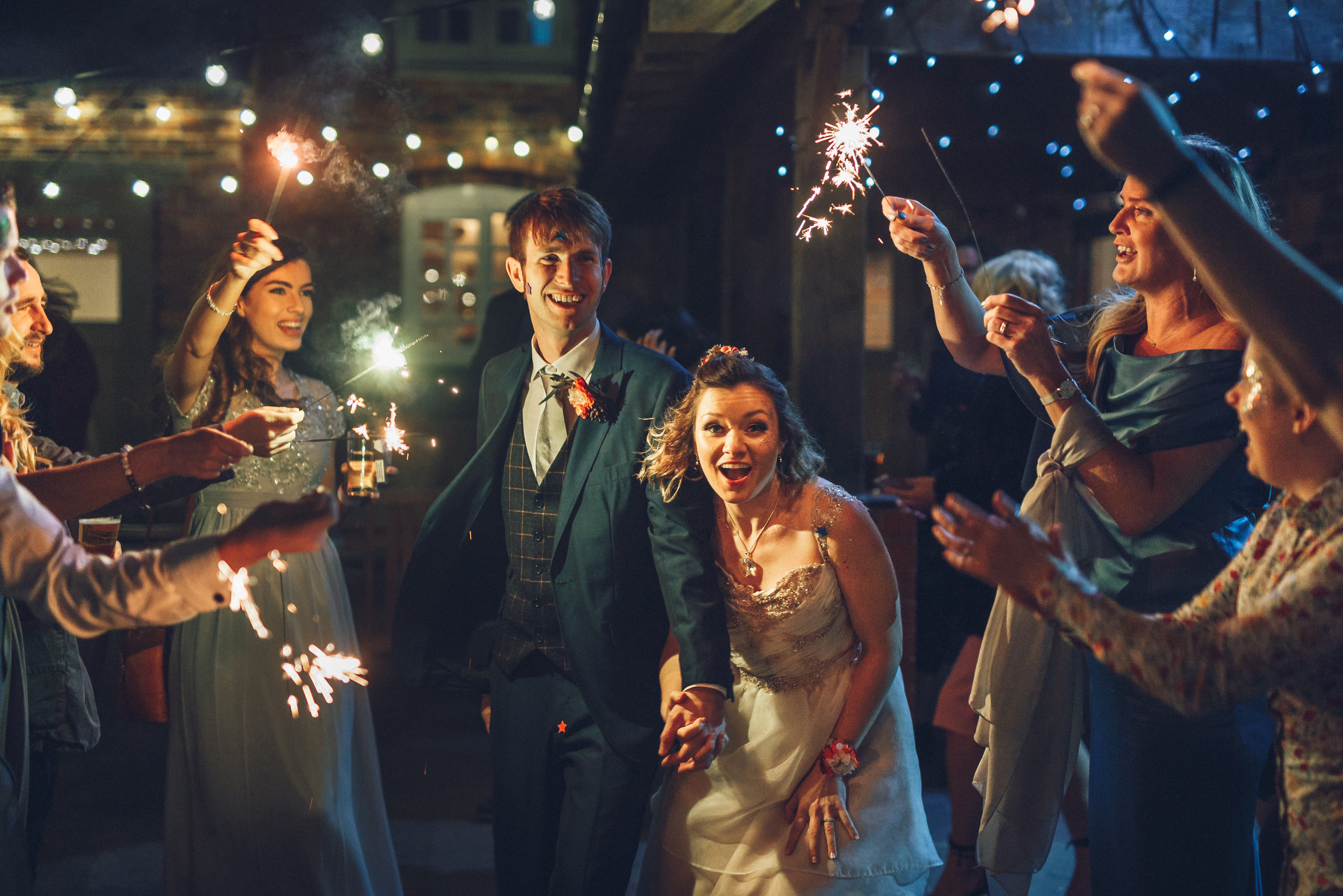couple running through sparklers newlyweds rustic winter wedding