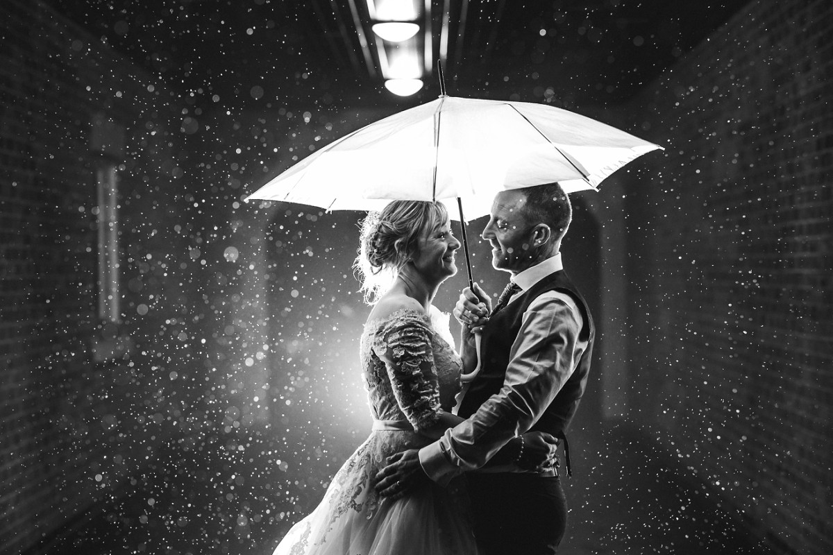 white hart inn wedding photography night portrait shot with couple in the rain under an umbrella